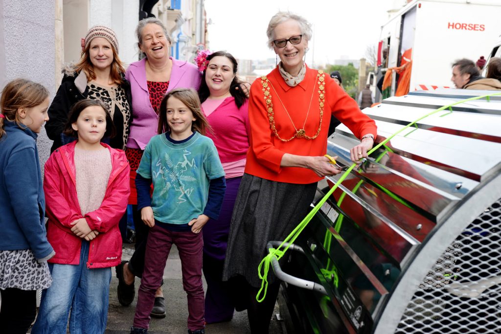 Group of people standing near the Bristol Mayor as she cuts the ribbon on the bike hangar