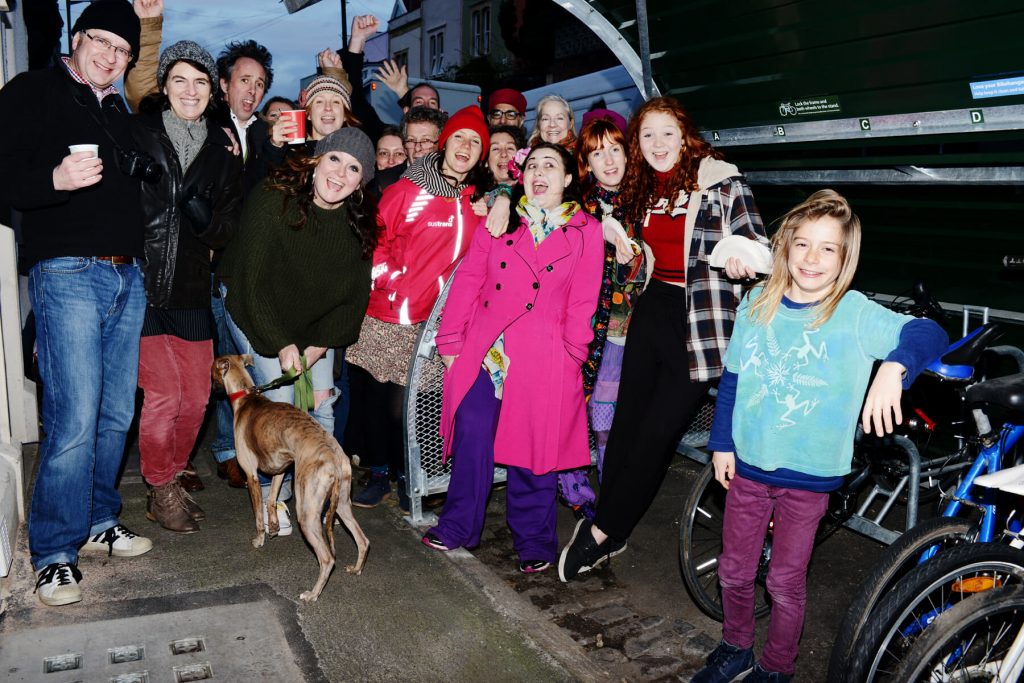 Group of people taking a photo near a bike hangar