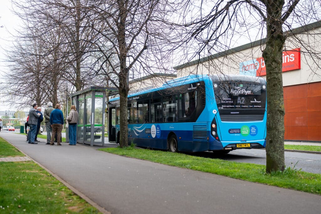 The blue branded A2 airport bus stopped at a bus stop outside of a Home Bargins in Portishead.