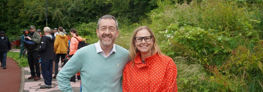 Left to Right, crowd of people in the background. Chris Boardman, National Active Travel Commissioner and West of England Mayor Helen Godwin in front of camera smiling.