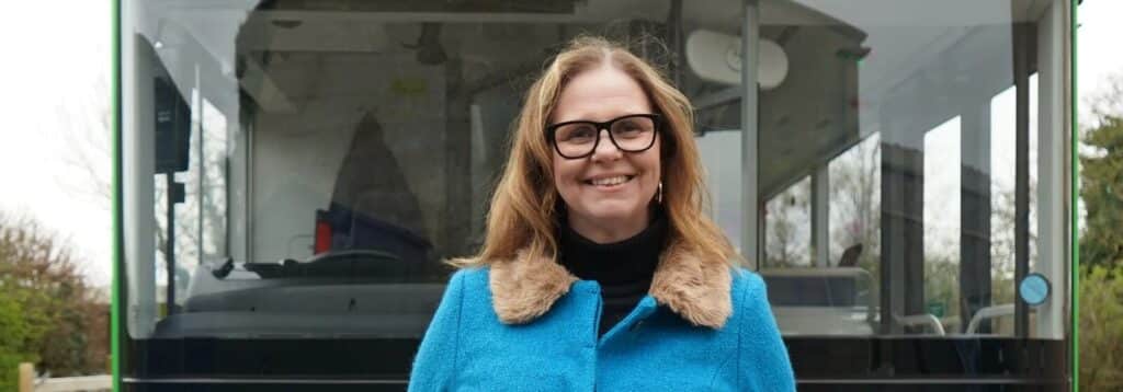 The West of England Mayor Helen Godwin wearing a blue coat stood infront of a Green bus.